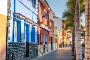 Tenerife. Colourful houses and palm trees on street in Puerto de la Cruz town, Tenerife, Canary...