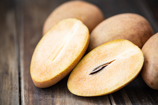 Sapodilla plum fruit on wooden table, exotic Thai fruit (La mood)