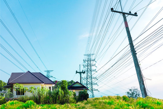 Background of electricity pole system with home, Power electricity distribution line to rural countryside, Concept of energy conservative, Electricity pylon with copy space to use as background