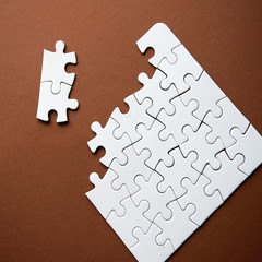 Close-Up Of Solved Jigsaw Puzzle On Brown Background