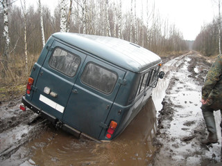 car stuck in a muddy deep pool in the forest