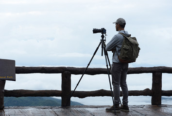 Young man travel photographer taking nature photo of mountain landscape  (Thailand )