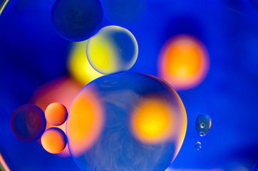 yellow and orange circles in oil spots on blue background