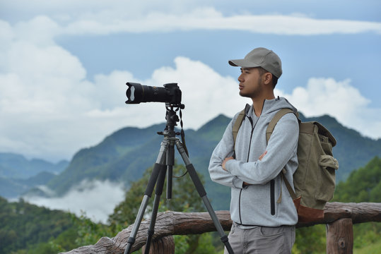 Young man travel photographer taking nature photo of mountain landscape  (Thailand )