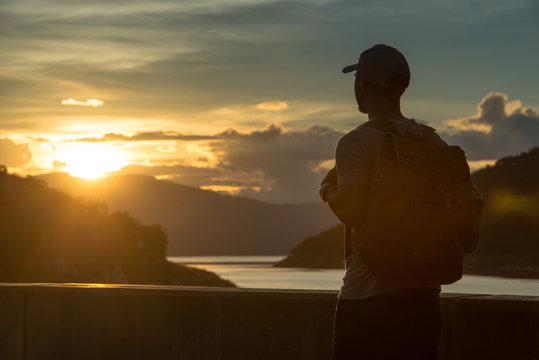 Image of sunrise with a silhouette of a tourist man in natural surrounding