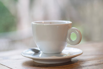 Coffee in white cup on desk as background