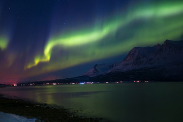 Naklejka na ściany i meble Northern lights in the sky over Tromso city, Norway