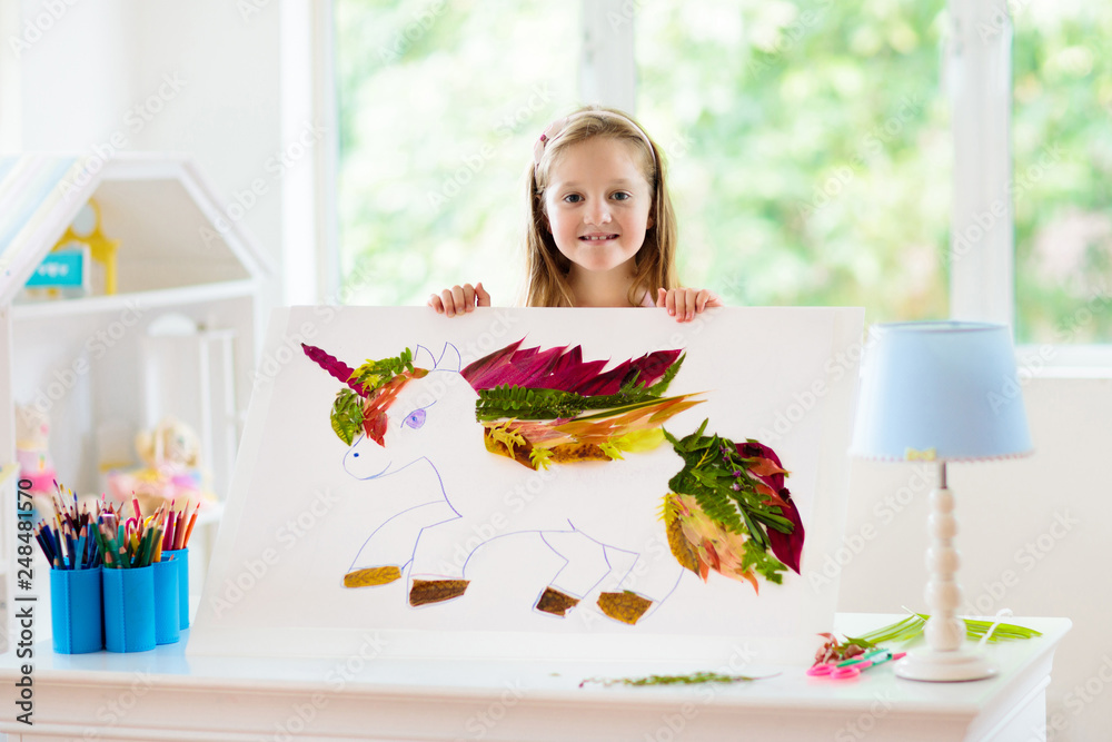 Wall mural Child drawing unicorn using tree leaves