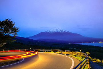 Light trails on mountain street on Fuji mountain light blue background in twilight, the light from...
