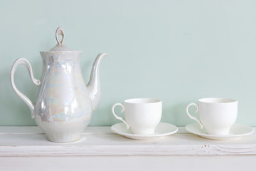 Set of tea cups and  ceramic teapot  on  shelf
