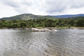 view of a landscape of a lake surrounded by mountains and trees