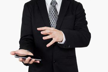 Businessman in Black Suit and Tie Holding Smartphone in Hand With Hand Gesture Over The Phones Screen Against White Background