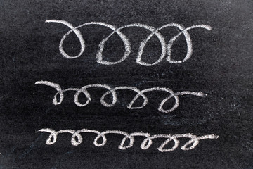 White chalk hand drawing in curve line shape on black board background