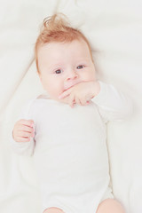 Happy child on the white blanket, blurred background