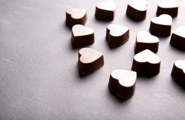 Chocolates in the shape of a heart on a dark background.