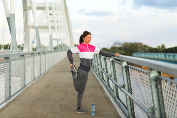 Active woman stretching legs on the bridge