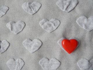 Obraz premium Grey heart shaped knitwear texture with red heart