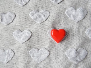 Obraz premium Grey heart shaped knitwear texture with red heart