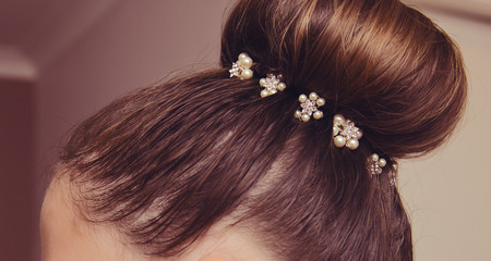 A beautiful wedding hair clip decoration, in a girls hair.  Pearl and shiny accessory.