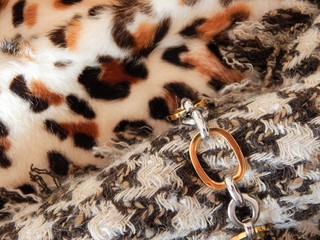 Opulent combination of trendy leopard print with hound tooth print and golden chain. 80`s style concept.