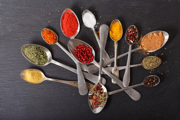 various herbs and spices for cooking in a spoons, top view