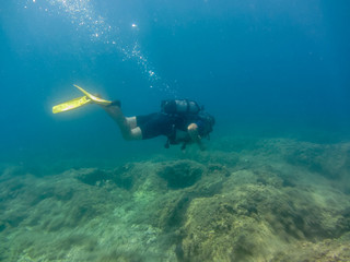 Young man with diving equipment  swimming underwater.Scuba diving  in Ionian sea. Greece, Corfu  vacation summer