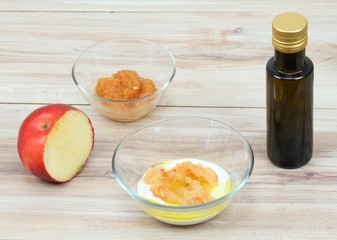 Face mask from apple,  fat cream and olive oil.  Ingredients for easy homemade facial mask on wooden background