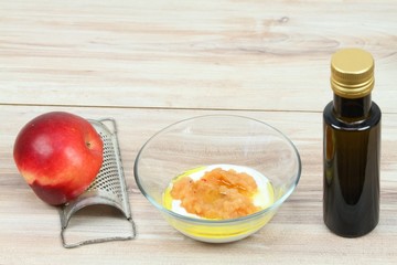 Face mask from apple,  fat cream and olive oil.  Ingredients for easy homemade facial mask on wooden background