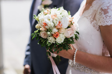 Obraz na płótnie Canvas A bride holding beautiful wedding bouquet. Close up