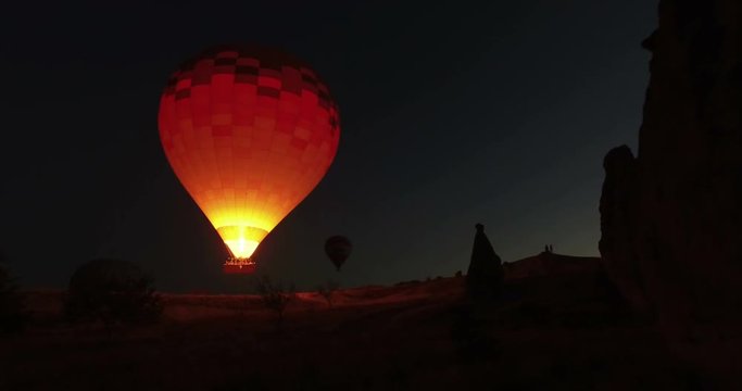 Hot air balloons flying at night sky in Cappadocia, Turkey.