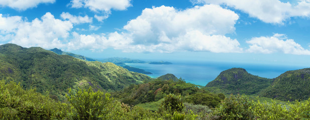 A stunning wide panoramic large format photograph of The mission lodge in the seychelles, overlooking the beaches and island of mahe. Paradise and beautiful blue sky.
