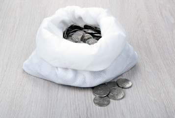 open white bag with russian ruble coins on a wooden background
