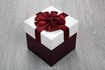 white gift box with a bow on a gray wooden background