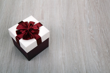 white gift box with a bow on a gray wooden background