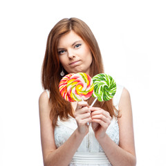 Sad, disappointed girl with candy. Isolated on white background.