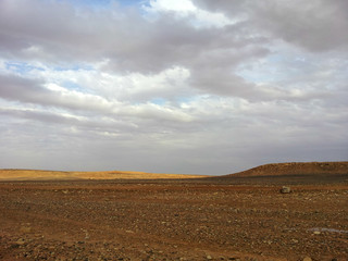Desert landscape in level Qassim Saudi Arabia, with a cloud in the sky