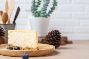 Homemade Cheese cake or butter cake put on wooden plate or dish with blueberry and place on table.