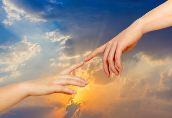 Two hands on a light background, a replica of the plot of Michelangelo's The Creation of Adam