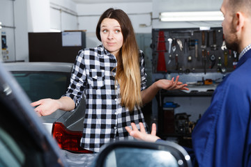 Fototapeta na wymiar Young woman is disappointed of tire replacement of her car in spring
