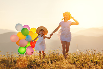 happy family mother and child with balloons at sunset in summer.