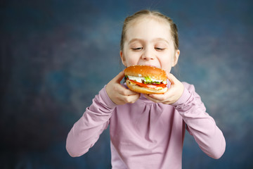 Naklejka premium Pretty American Little Girl Eating Burger. Unhealthy Eating Concepts