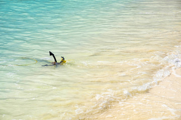 Anchor in waves on white sand beach
