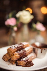 Cinnamon sugar dusted churros with chocolate sauce. Concept of food, dessert and baking. Traditional Mexican food.