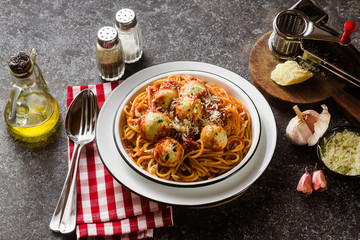 Italian pasta spaghetti with ricotta cheese balls in tomato sauce on the table with parmesan cheese. healthy traditional italian food for the whole family, party or restaurant menu