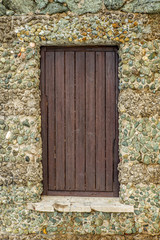 A window on an old wall in the town of Castiglioncello in Tuscany