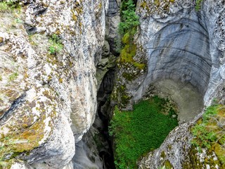 An interesting and unique view of Johnstone Canyon in Banff National Park, Alberta, Canada.  The canyon was caused by erosion of limestone rock.  This view looks down to the bottom of the canyon.