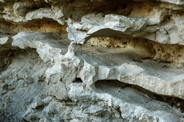 Picturesque background of collapsing surface of limestone rock. Abstract beautiful forms of weathering stone rocks, huge cracks and washed cavitie in stone, danger of collapse and landslide earthquake