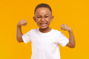 Agression, bullying, negative reaction and emotions. Picture of angry mad little boy of American...