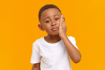 People, negative emotions, health and illness concept. Sad unhappy dark skinned male child having...