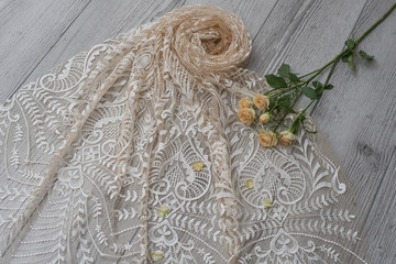 The texture of lace on wooden background decoreted roses.